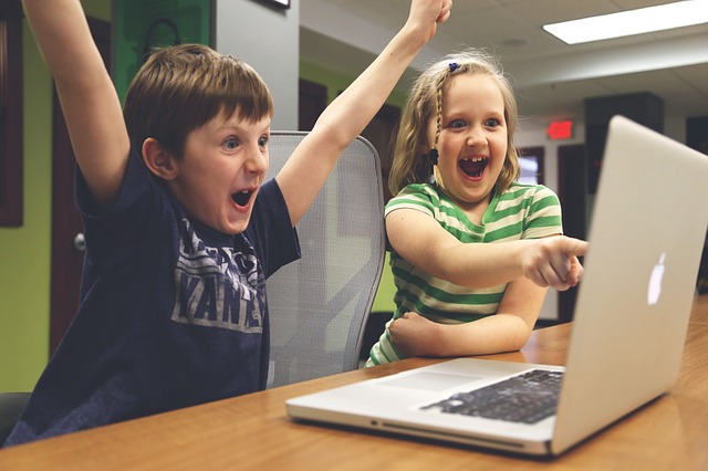 パソコンを見て喜ぶ二人の子ども
