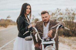 バイクに腰掛ける男性と、手を添える女性