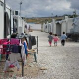 難民キャンプで歩く3人の子供